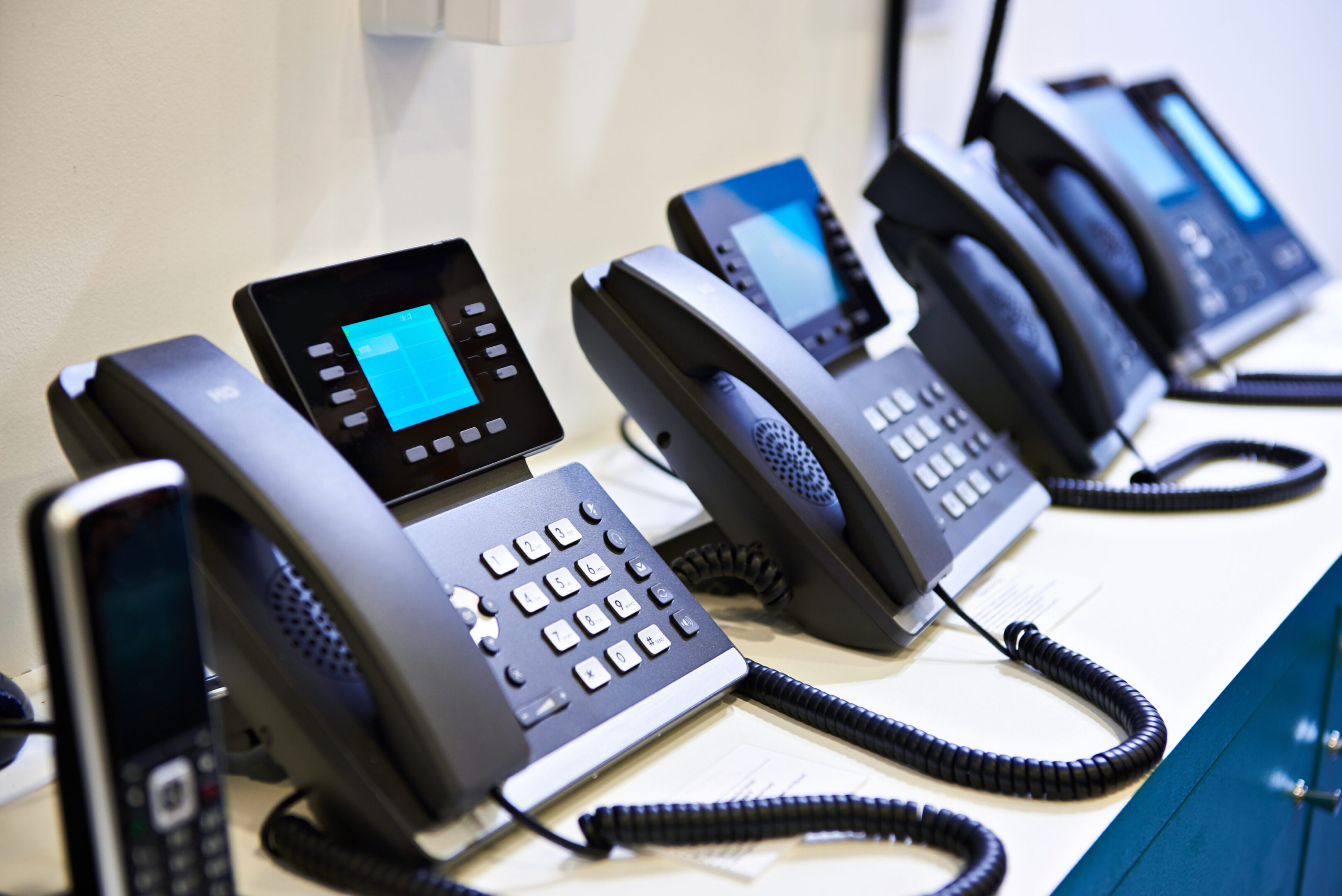 Office desk phones in a row.